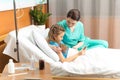 Doctor and little girl using digital tablet and sitting on bed Royalty Free Stock Photo