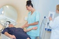 Doctor looking at female patient going through ct scan