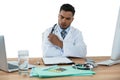 Doctor looking medical report at desk Royalty Free Stock Photo