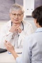 Doctor looking at patient, smiling Royalty Free Stock Photo