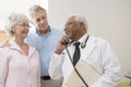 Doctor Looking At Patients While Using Landline Phone