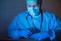 Doctor with cap and mask in his office.