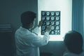 Doctor looking at x-ray film. patient woman who is listening to diagnosis Royalty Free Stock Photo