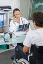 Doctor looking at xray patient in wheelchair Royalty Free Stock Photo