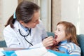 Doctor looks mouth of child