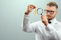 The doctor looks at a test tube with liquid through a magnifying glass, loupe. Scientific research concept, vaccine invention,