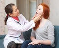 Doctor looks throat of teenager girl