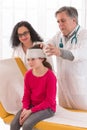 Doctor makes a bandage to little girl head