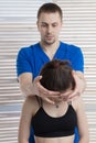 The doctor makes a diagnosis of the head and cervical spine of a young girl. Massage and manual therapy