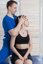 The doctor makes a diagnosis of the head and cervical spine of a young girl. Massage and manual therapy