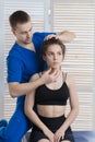 The doctor makes a diagnosis of the head and cervical spine of a young girl. Massage and manual therapy