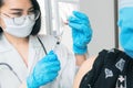 Doctor makes vaccination in the shoulder of female patient in a hospital. Vaccine or flu shot in injection needle Royalty Free Stock Photo