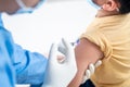 Doctor making a vaccination in the shoulder of patient boy or child person,Flu Vaccination Injection on Arm, coronavirus,covid-19