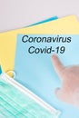 Doctor man finger pointing Coronavirus written on blue folder paperwork covid-19