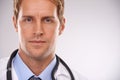 Doctor, man and portrait in studio for health, medic or diagnosis with stethoscope for job on mockup. Young person or Royalty Free Stock Photo