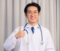 Doctor man smiling and stethoscope neck strap show finger thumb up