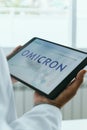Doctor man and text omicron in a tablet