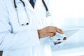 Doctor man using tablet computer for network research or virtual disease treatment, hands close-up. Perfect medical Royalty Free Stock Photo