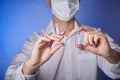 Doctor in mask with a injection syringe on the blue background Royalty Free Stock Photo