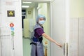 Doctor in a mask over face and surgery uniform shutting the door to the operating unit