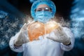 Doctor in a mask shows a model of the liver on a blurred background