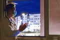 Doctor with mask and stethoscope clapping out the window