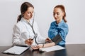 Doctor measures blood pressure with a tonometer to a woman patient at a medical appointment in a clinic Royalty Free Stock Photo