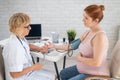 The doctor measures the pressure of a pregnant woman. Royalty Free Stock Photo