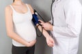 Doctor measures the pressure of a pregnant woman on colourful background Royalty Free Stock Photo