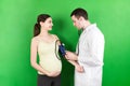 Doctor measures the pressure of a pregnant woman on colourful background Royalty Free Stock Photo