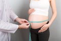 Doctor measures the pressure of a pregnant woman on colourful background Royalty Free Stock Photo