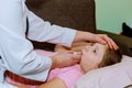 Doctor measures temperature of sick little girl on bed. Doctor checking thermometer Royalty Free Stock Photo