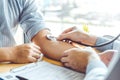 Doctor Measuring arterial blood pressure man patient on right arm Health care hospital and medicine concept Royalty Free Stock Photo