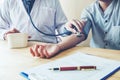 Doctor Measuring arterial blood pressure woman patient on arm He Royalty Free Stock Photo