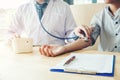 Doctor Measuring arterial blood pressure woman patient on right