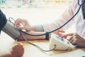 Doctor Measuring arterial blood pressure woman patient on right