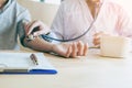 Doctor Measuring arterial blood pressure woman patient on right