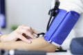 Doctor measuring blood pressure on patient shoulder using sphygmomanometer closeup