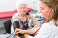 Doctor measuring blood pressure of senior patient