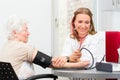 Doctor measuring blood pressure of senior patient