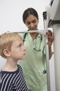 Doctor Measuring Height Of A Boy