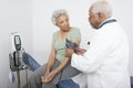 Doctor Measuring Patient's Blood Pressure At Clinic