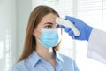 Doctor measuring patient`s temperature with non contact infrared thermometer in office Royalty Free Stock Photo