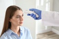 Doctor measuring patient`s temperature with non contact infrared thermometer in office Royalty Free Stock Photo