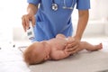 Doctor measuring temperature of little baby with non-contact thermometer in clinic, closeup. Health care Royalty Free Stock Photo