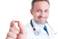 Doctor or medic holding and showing one red pill Royalty Free Stock Photo