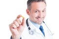 Doctor or medic holding and showing one yellow pill Royalty Free Stock Photo