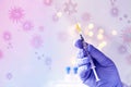 Doctor, medic holds in hand a thin syringe for intramuscular injection on a technological blue background, prepares to do