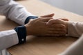 Doctor, medic nurse holding hand of mature patient at appointment