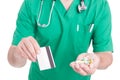Doctor, medic or pharmacist holding pills and credit card